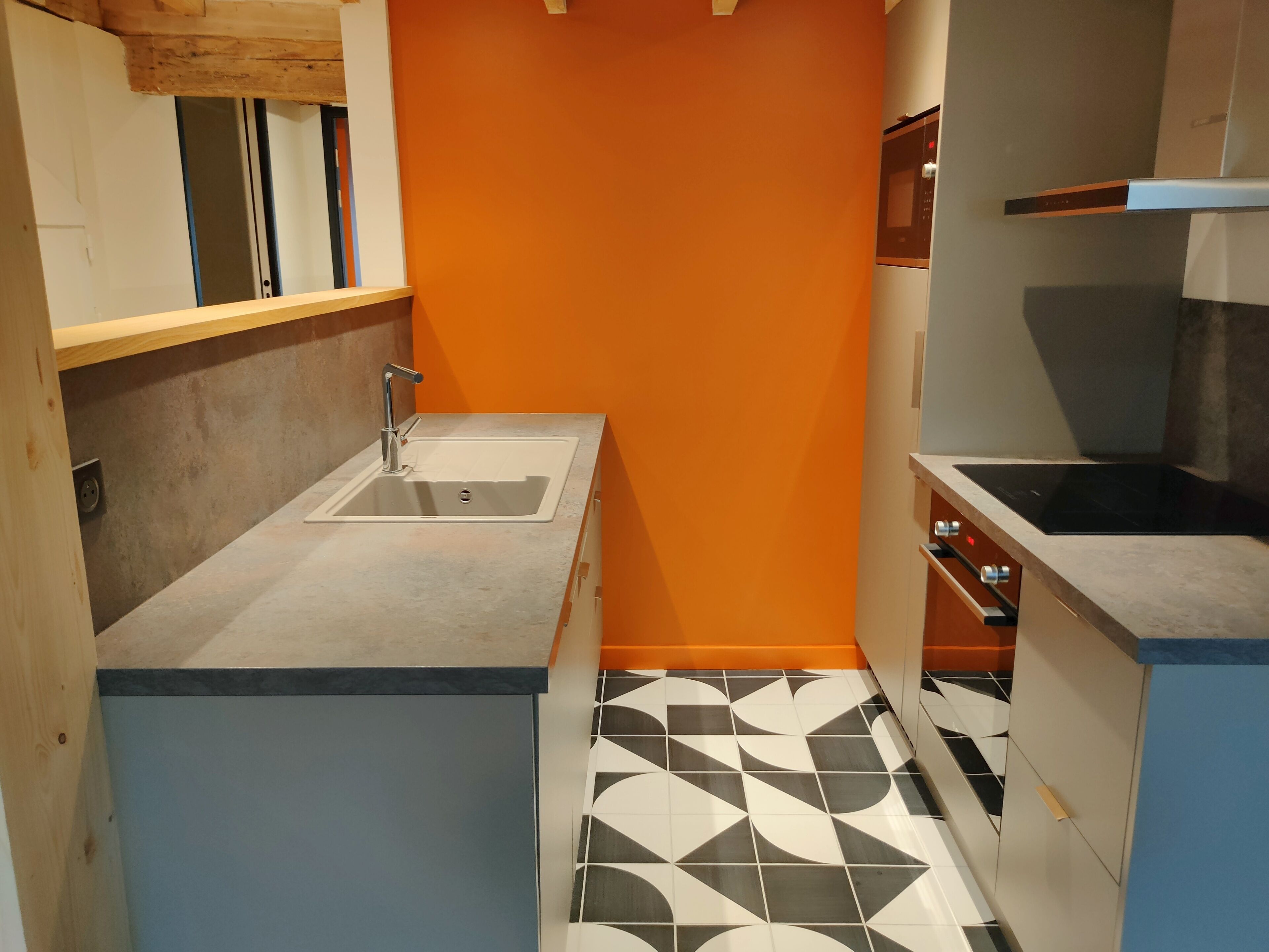 A compact kitchen with a sink, a microwave, and a stove.