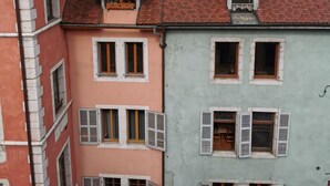 A row of colorful buildings with distinct architectural styles, including a building with a sign reading "Chez Gaston". - Old Annecy - 4-star apartment - near the lake - Pâquier - Historic center (Annecy)