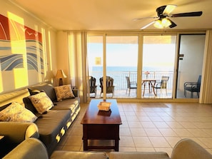 Enjoy the ocean view from your balcony, featuring a sofa set and table with chairs.