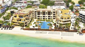 A resort with multiple buildings, a central pool, and a beach. - Beautiful and comfortable apartment in a condominium facing the sea (Playa del Carmen)