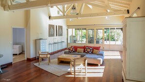 A spacious living area with a wooden ceiling, a sofa set, a coffee table, and a cabinet. - DOMAINE DE CEZAC-Proche Bordeaux-St-Emilion-Arcachon-Blaye (Cezac)