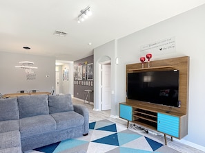 Relax in this stylish living room with a large flat-screen TV, comfortable sofa, and geometric-patterned rug.