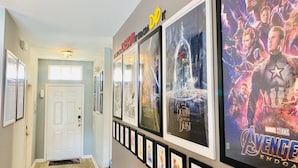 Un pasillo decorado con carteles de películas enmarcados, incluyendo 'Star Wars: The Force Awakens' y 'Beauty and the Beast'.