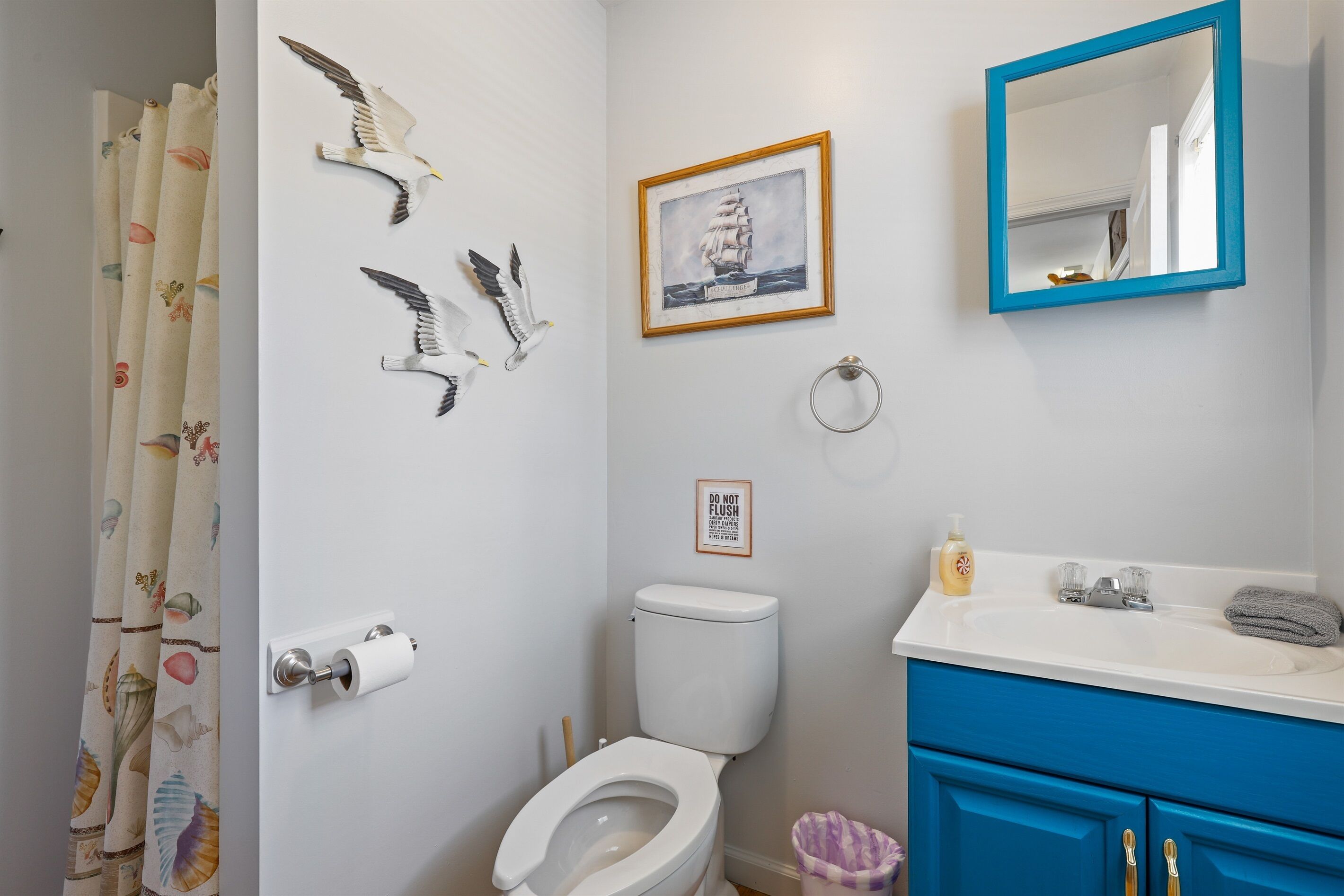 A bathroom with a toilet, sink, and shower curtain.
