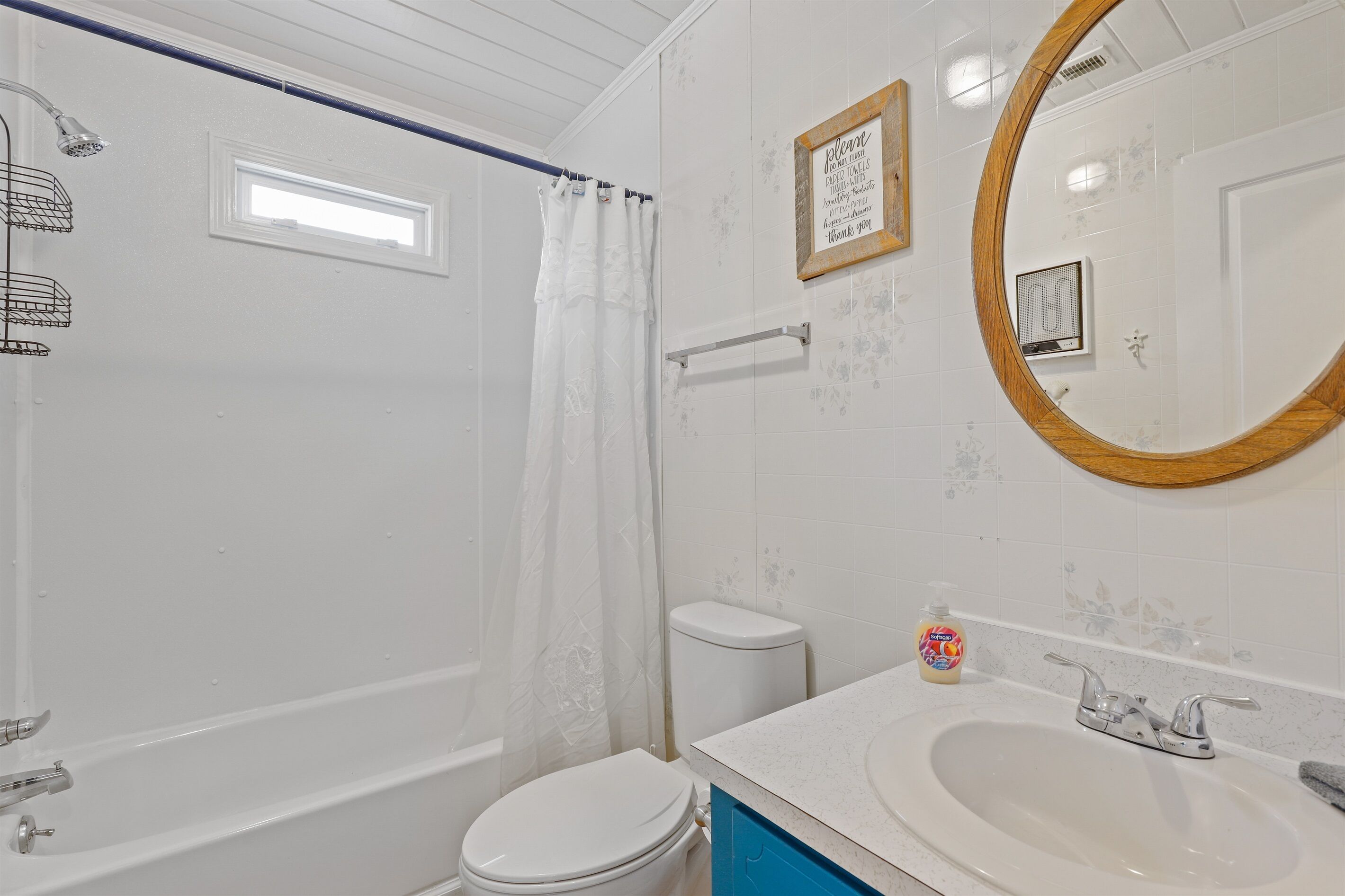 A bathroom with a bathtub, toilet, sink, and a shower curtain.