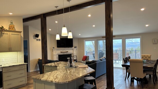 A spacious kitchen with a marble island, wooden beams, and a dining area with a view. - Sunrise at the Sawmill - Couples Retreat! (Dundee)
