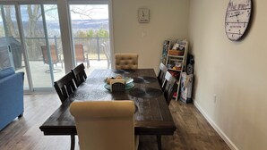 A dining area with a wooden table, chairs, and a view through a glass door to the outdoors. - Sunrise at the Sawmill - Couples Retreat! (Dundee)