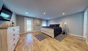 Relax in this serene bedroom with a large bed and a stylish dresser.