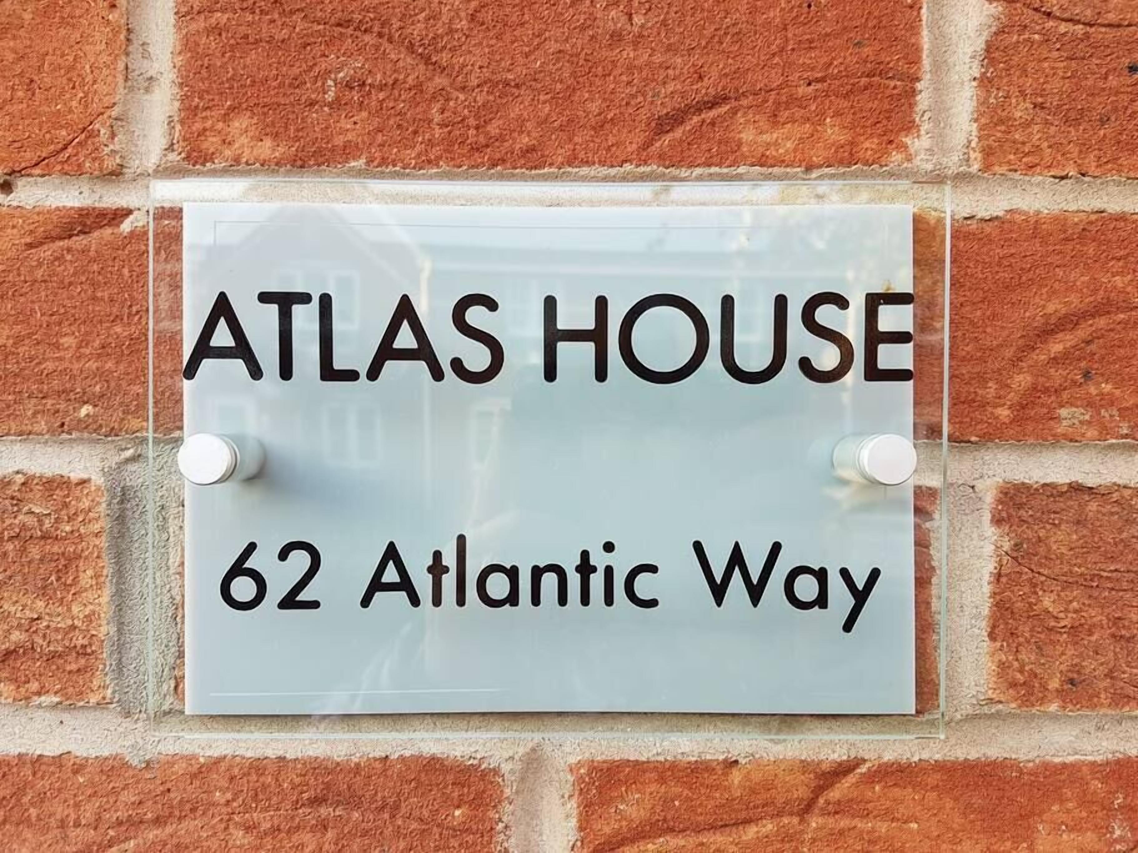 Een bordje met 'ATLAS HOUSE' op '62 Atlantic Way'.