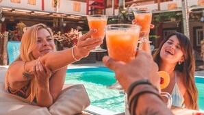 A poolside setting with a table, food, and drinks. - Hotel Ferrugem Eco Village (Garopaba)