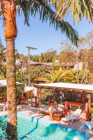 Una piscina al aire libre, sillones reclinables de piscina