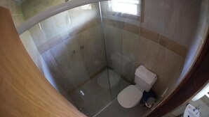 A bathroom with a glass-enclosed shower, a toilet, and a sink. - Hotel Ferrugem Eco Village (Garopaba)