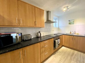 Enjoy cooking in this well-equipped kitchen with a microwave, toaster, kettle, and oven, and take in the view from the window.