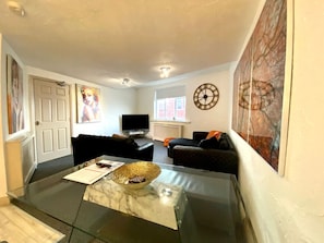 Relax in this stylish living room with a comfortable sofa, coffee table, and large TV.