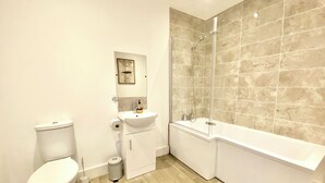Un baño moderno con inodoro, lavamanos y bañera.