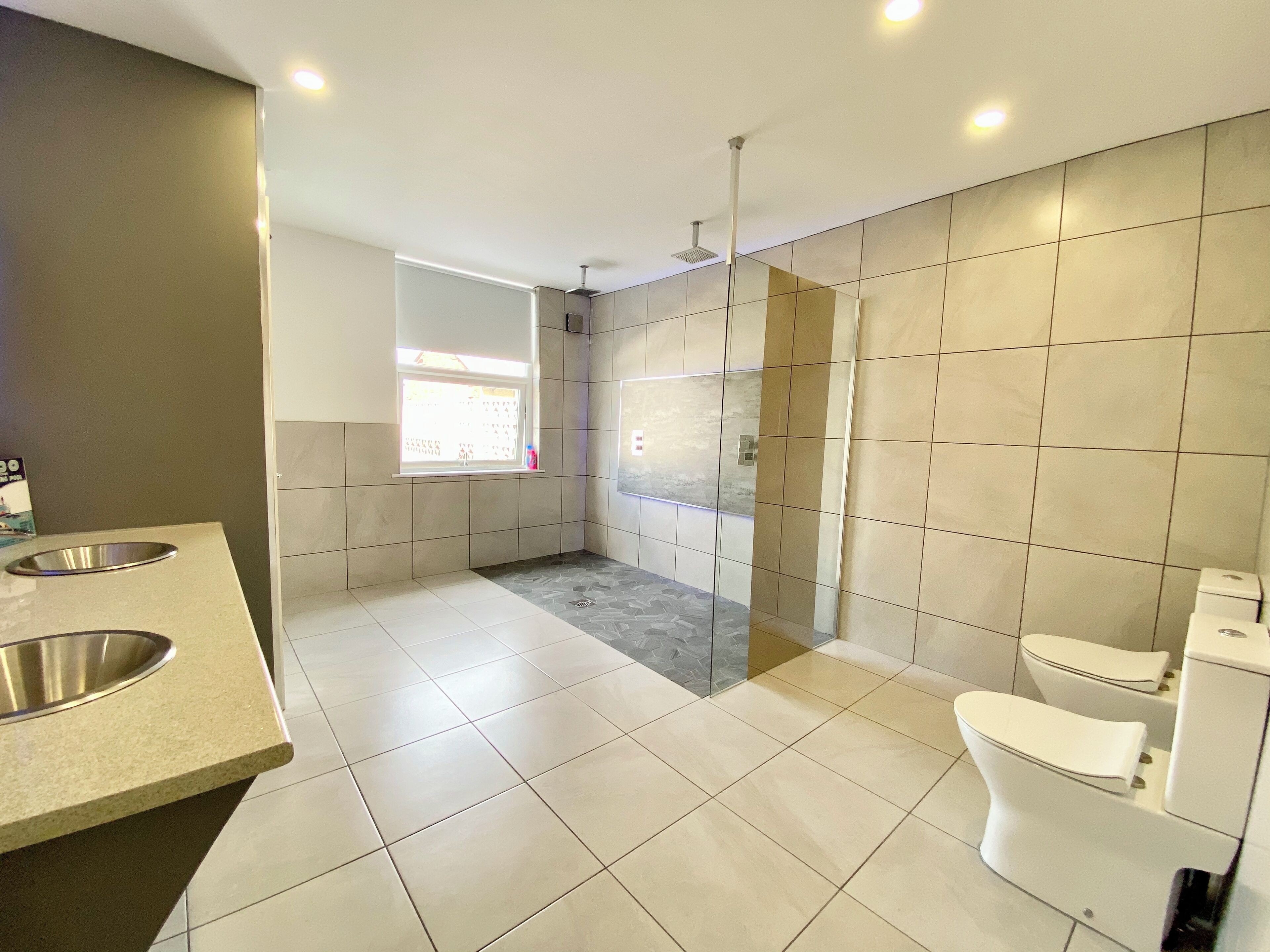 Un baño moderno con ducha, inodoro y lavamanos.