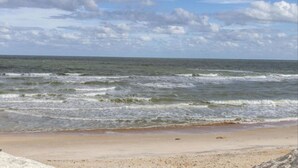 A beach with waves and a clear sky.