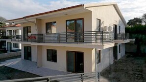 Una moderna casa a due piani con un balcone, ampie finestre e un tetto piatto.