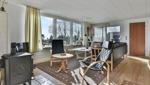 Ein großzügiges Wohnzimmer mit großen Fenstern, einem Kamin und einem Essbereich.