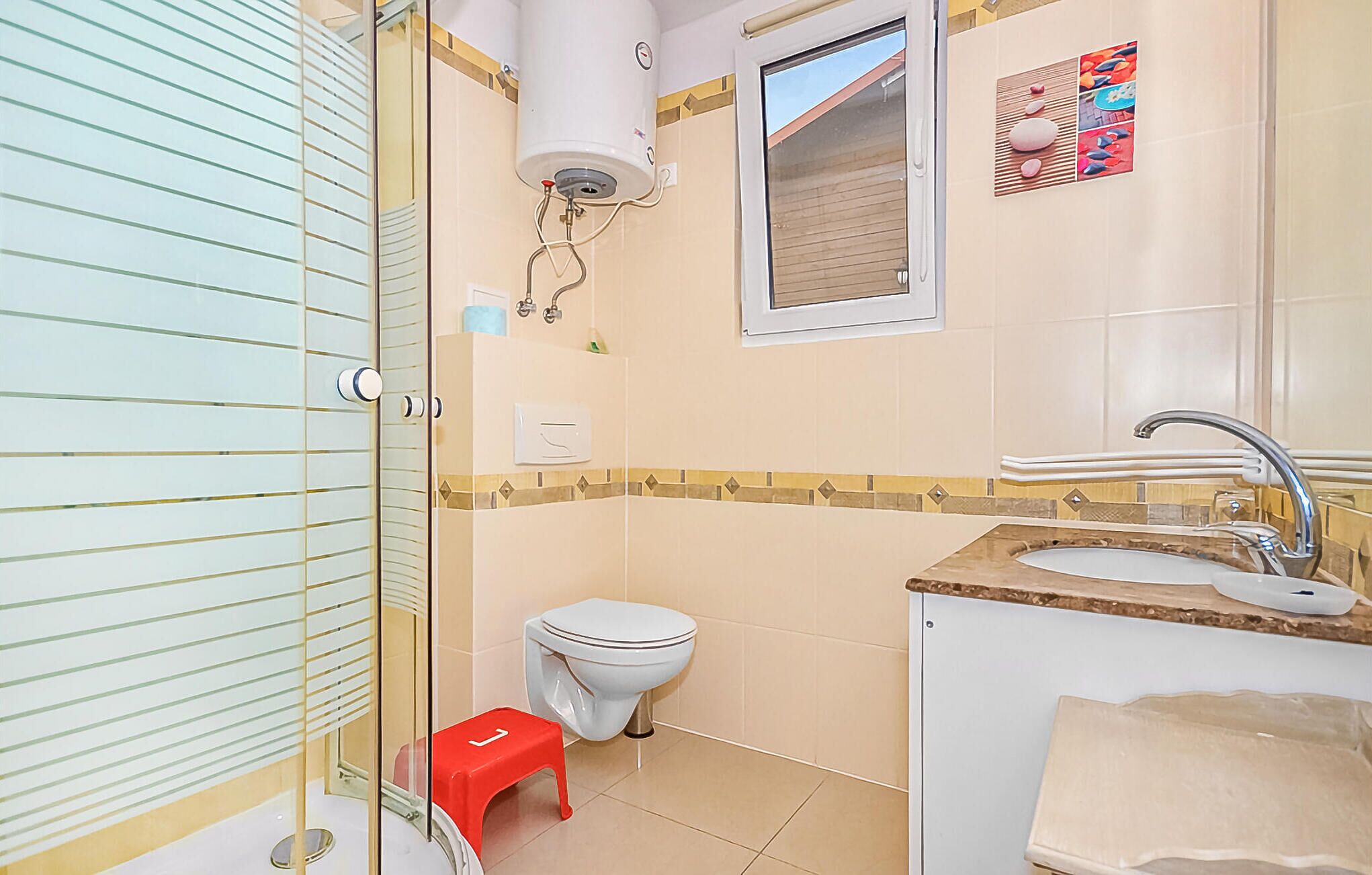 A bathroom with a toilet, sink, and shower.
