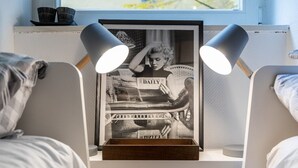 A bedroom with a bed, a bedside table with a framed picture, and two bedside lamps. - Loft Munich Old Town (München)
