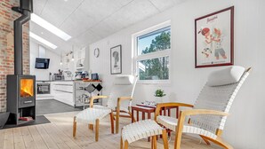 Una cocina moderna con estufa integrada, sillas de madera y un ventanal grande.