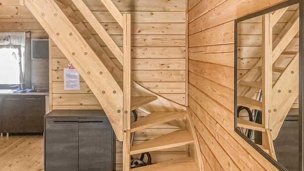 Een houten interieur met een trap en een keukenhoek.