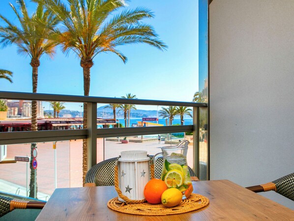 A balcony with a view of palm trees and a beach.
