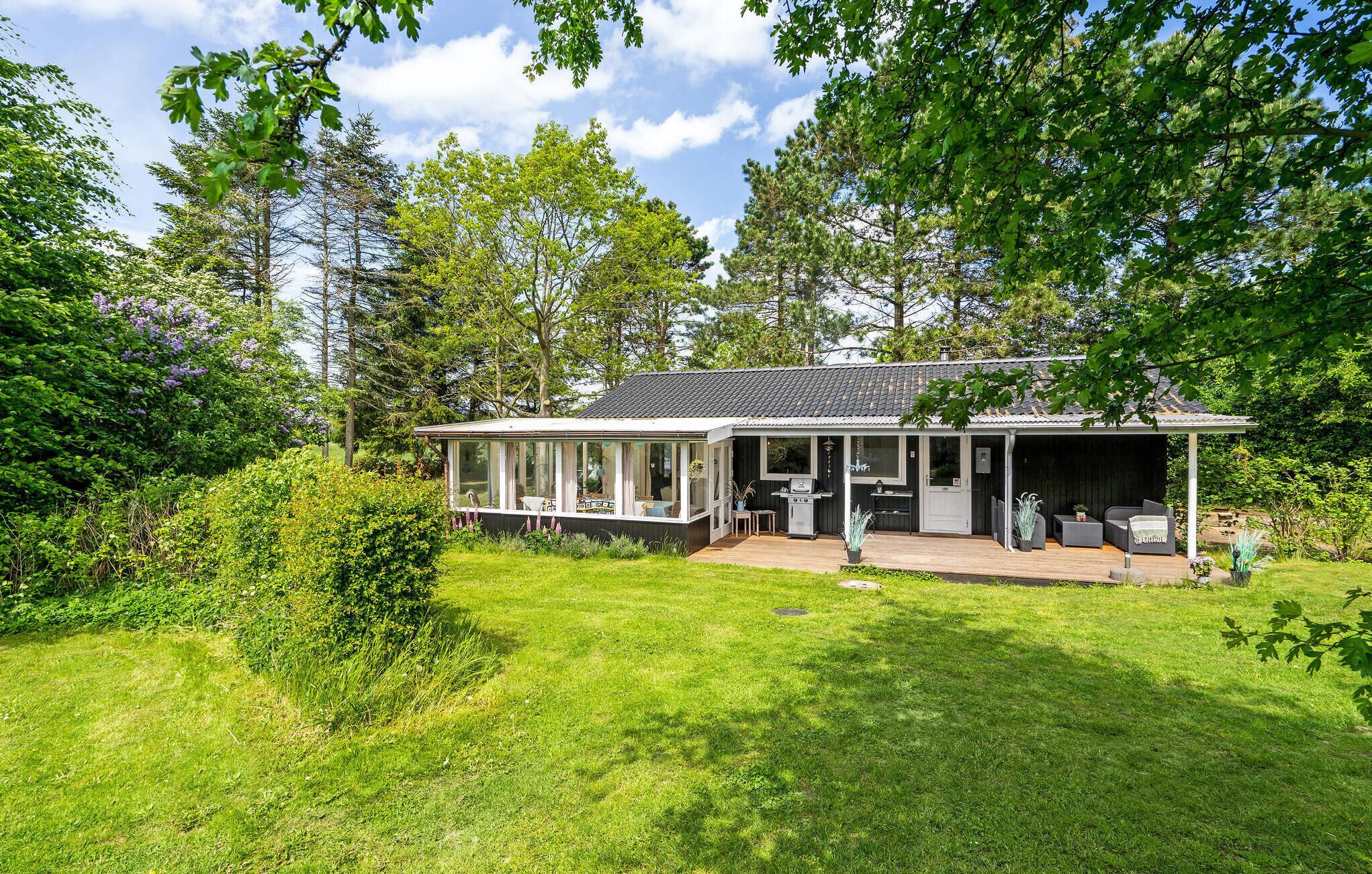 Une maison dotée d’un patio couvert, d’un espace barbecue et d’une pelouse.