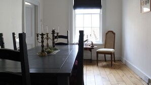 A dining room with a dark wooden table, four chairs, a small side table with candles, and a window with a dark valance. - 4bedhouse/leominster/hiking/castles/sleeps7/wifi (Leominster)
