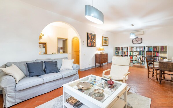 A living room with a sofa, armchairs, a coffee table, a bookshelf, and a dining area. - Beautiful home in Camaiore with WiFi (Camaiore)