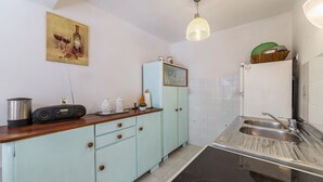 Cuina petita amb un rentaplat, una ràdio i un armari.