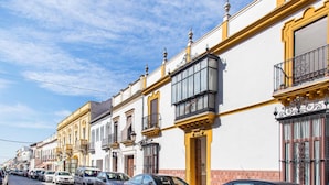 A row of historic buildings with balconies and a cobblestone street.
