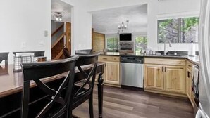 A modern kitchen with wooden cabinets, a central island, and a large window providing natural light.