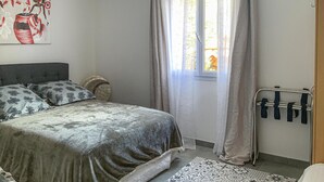 A bedroom with a bed, pillows, a window with curtains, and a radiator. - Gorgeous home in Mallemort (Mallemort)