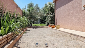 A courtyard with a gravel surface, a wooden fence, and potted plants. - Gorgeous home in Mallemort (Mallemort)