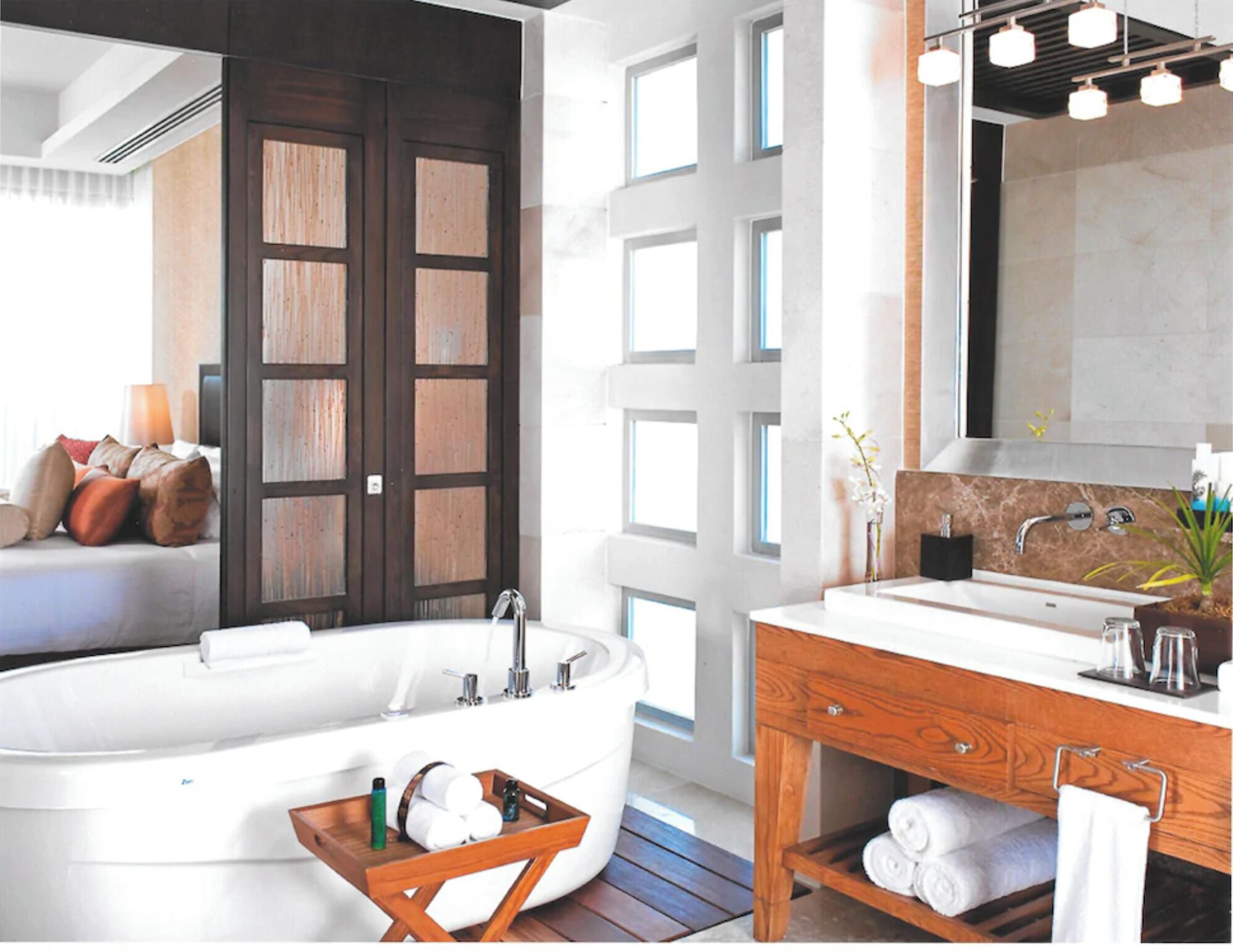 A modern bathroom with a freestanding bathtub, a wooden vanity, and a large mirror above the sink.