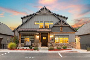 A two-story building with a gabled roof, a front porch with a bench, and a stone foundation. - Table Rock Lake View! Two Community Pools! (Branson)