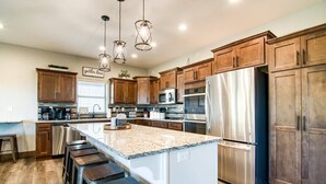 A modern kitchen with wooden cabinets, stainless steel appliances, and a granite countertop. - Table Rock Lake View! Two Community Pools! (Branson)
