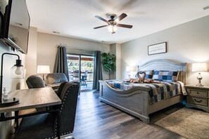 A bedroom with a bed, a desk, a chair, a ceiling fan, and a view of the outdoors. - Table Rock Lake View! Two Community Pools! (Branson)