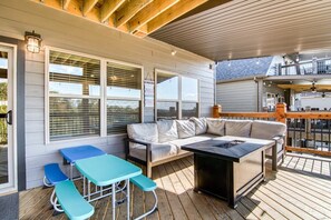 A covered deck with a sofa, two blue tables, and a grill. - Table Rock Lake View! Two Community Pools! (Branson)