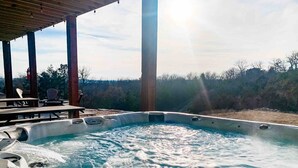 A hot tub with a wooden deck and chairs, surrounded by a natural landscape. - Table Rock Lake View! Two Community Pools! (Branson)