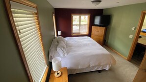A bedroom with a bed, a nightstand, a lamp, a TV, and a wardrobe. - Fantastic location; 2 bdrm w/ private hot tub (Sun Peaks)
