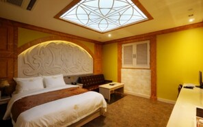 A bedroom with a large bed, a nightstand, a small table, a bench, and a skylight. - Dongtan Windsor Hotel (Hwaseong)