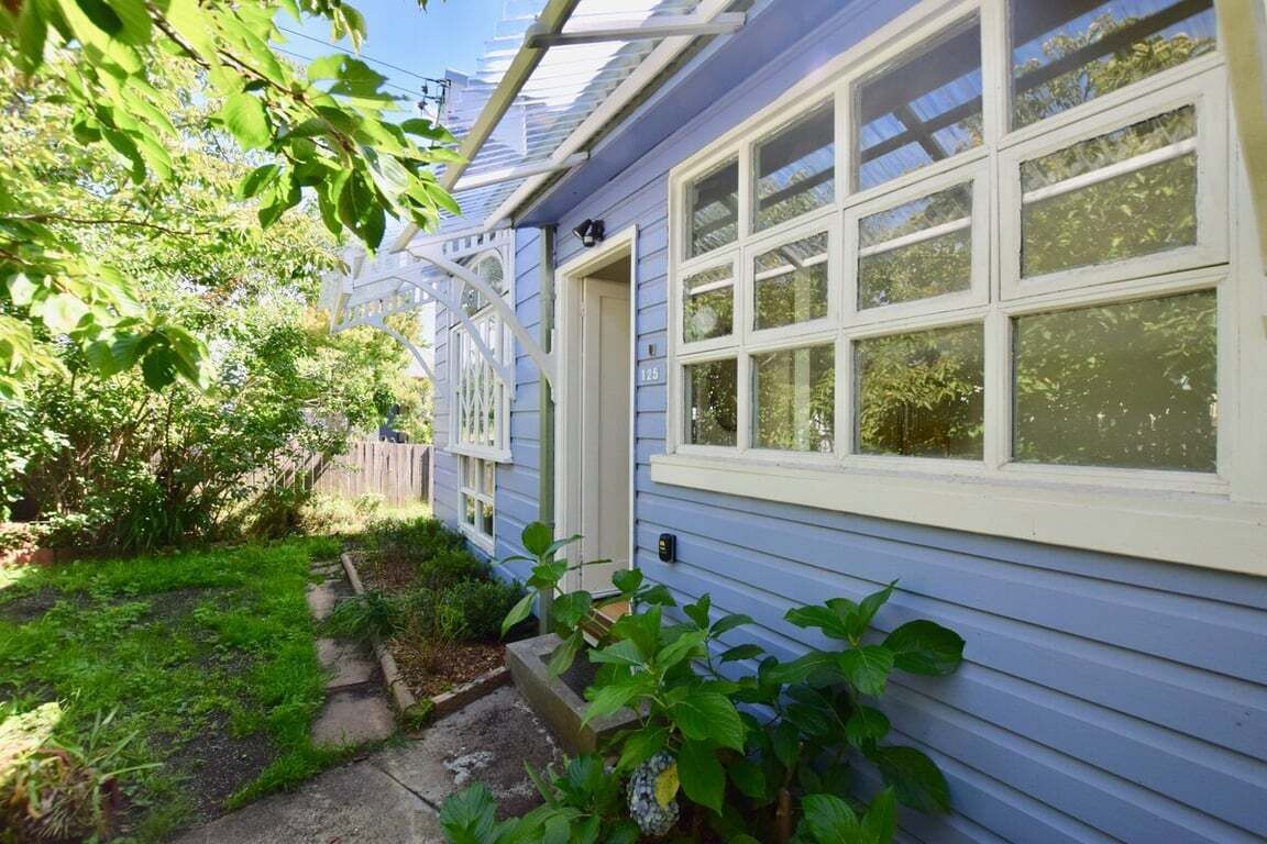 Une maison avec un porche abrité, une porte bien visible et une fenêtre.