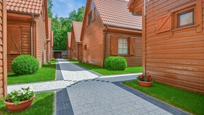 A row of wooden cabins with tiled roofs, a paved walkway, and green lawns. - 2 bedroom gorgeous home in Dabki, Bobolin (Dabki, Bobolin)