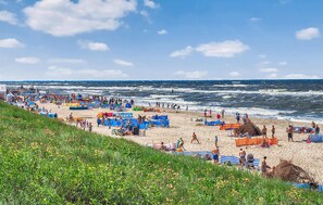 Una playa concurrida, con muchos sombrillas y gente.