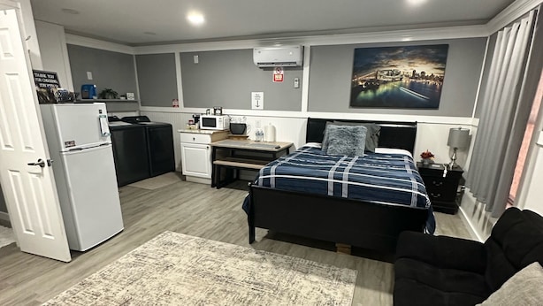 A compact hotel room with a bed, a small kitchenette, a dining table, and a sofa. - Guesthouse studio Generac backup powered w washer&dryer. Fully equipped. (Spring)
