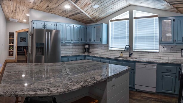 A kitchen with blue cabinets, a granite countertop, and a built-in dishwasher. - Flaming Gorge getaway/ Fly fishing paradise! (Dutch John)