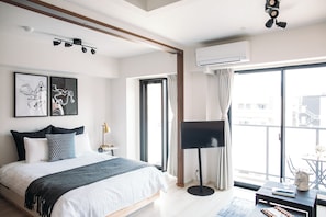 Ett modernt hotellrum med en säng, en platt-TV, en luftkonditioneringsanläggning och ett stort fönster med utsikt.